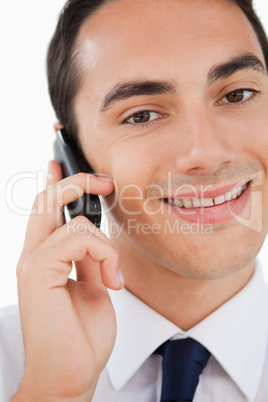 Close-up of a smiling man in a suit calling with his cellphone