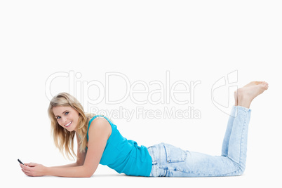 A woman lying on the floor with her legs held up is holding her