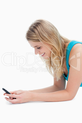 A smiling woman is texting on her mobile phone