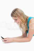 A smiling woman is texting on her mobile phone