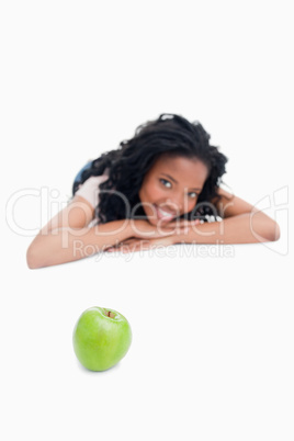 A green apple with a young girl in the background