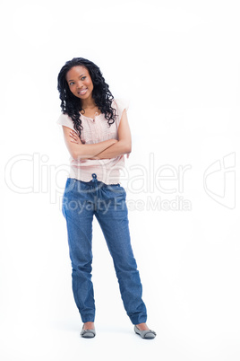 A young woman standing with her arms folded is smiling
