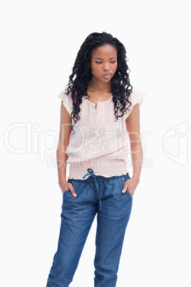 A young woman is thinking and standing with her hands in her poc