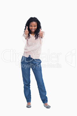 A young woman standing with her thumbs up