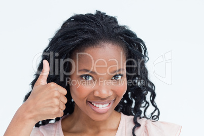 A young woman smiling at the camera with her thumb up