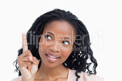 Head shot of a happy young woman with her finger held up