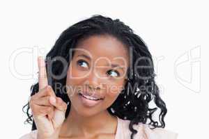 Head shot of a happy young woman with her finger held up