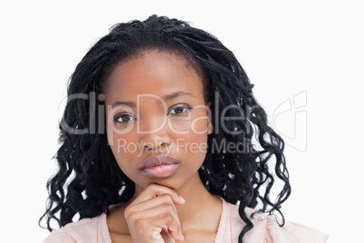 A woman staring at the camera resting her head on her hand