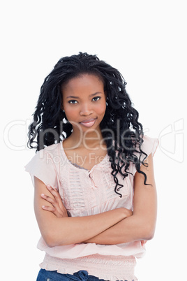 A woman with her arms folded is staring at the camera