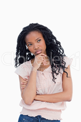 A young woman is thinking and resting her head on her hand