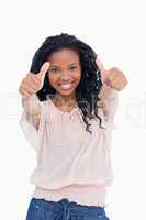 A woman is smiling and has her both thumbs up