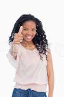 A girl is smiling and giving a thumb up