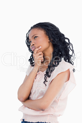 A young woman resting her head in her hand is thinking