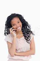 A young woman looking at the camera is talking on her mobile pho