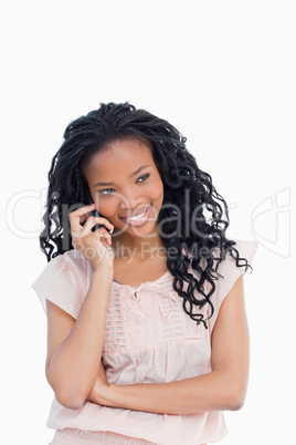A smiling young woman is talking on her mobile phone