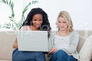 Two women sitting down looking at a laptop