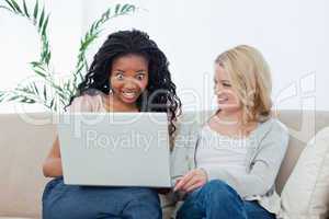 A surprised woman looking at a laptop with her friend