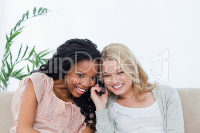 Two women are listening to a mobile phone