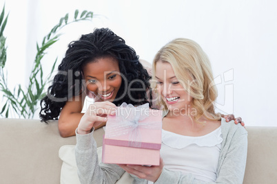 Two women look inside a pink box