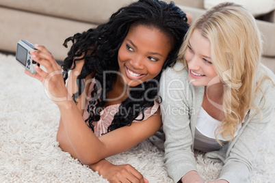 Two women lying on the floor are posing for a picture