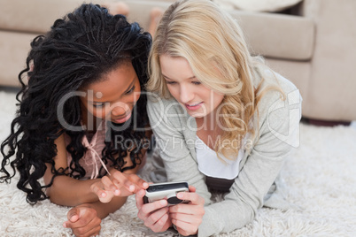 Two women are looking through photos on a digital camera