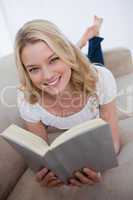 A smiling woman is holding a book
