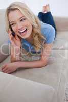 A woman talking on her mobile phone is laughing