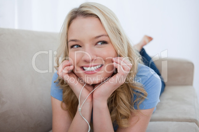 A smiling woman is listening to music with her earphones