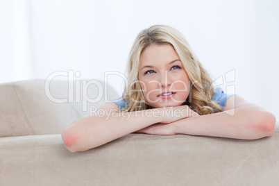 A woman resting her chin on her hands is thinking