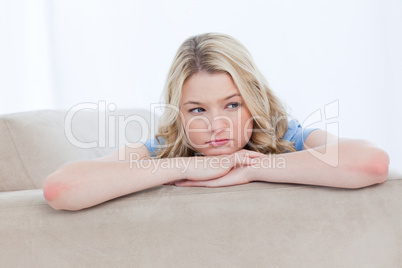 A young woman resting her head on her hands is thinking
