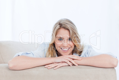 A smiling woman looking at the camera is resting her chin on her