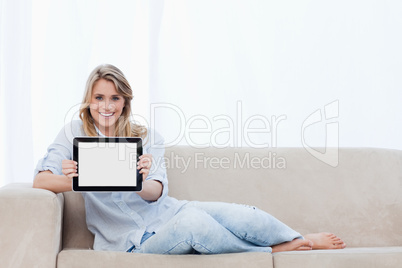 A smiling woman holding a tablet on in front of her