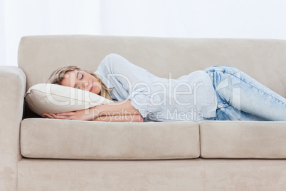 A sleeping woman is lying on a couch