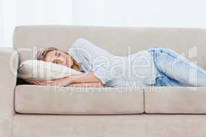 A sleeping woman is lying on a couch