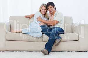 A couple sitting on a couch embracing each other