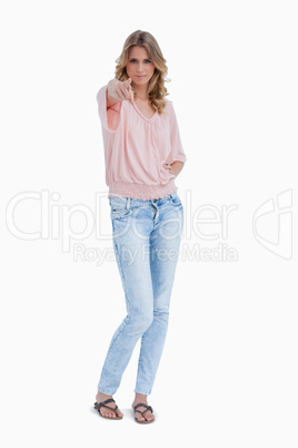 A woman is standing up and pointing at the camera