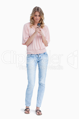 A woman standing holding her mobile phone