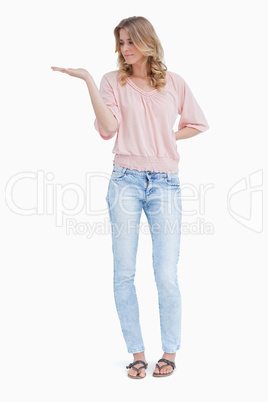 A woman is standing with her palm held out flat