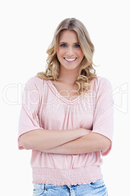 A smiling woman standing with her arms folded