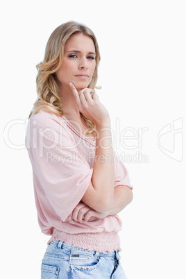 A woman with her hand held up to her face is thinking