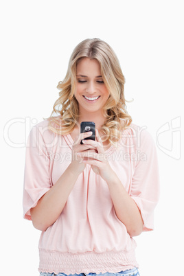 A smiling woman looking at her mobile phone