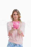Woman holding a piggy bank in the palms of her hands