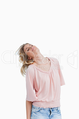 A woman with her eyes closed holds her head back