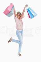 A woman is standing holding up shopping bags