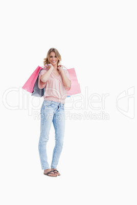 A woman is carrying shopping bags over her shoulder