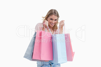 A smiling woman is carrying shopping bags