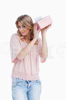 Peaceful young woman shaking her gift