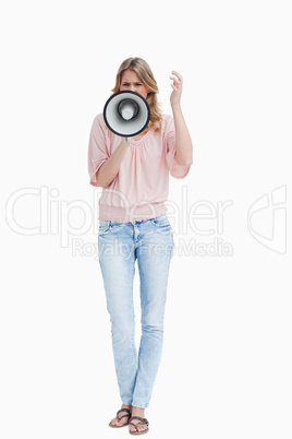 Front view of a young woman shouting with a megaphone