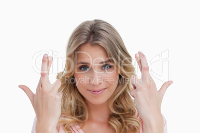Smiling young woman crossing her fingers