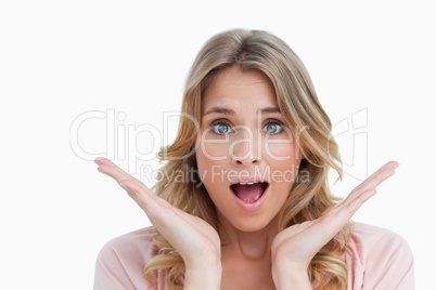 Surprised young woman raising her hands